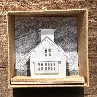 white paper gable fronted house with double chimney on plywood base  in presentation box