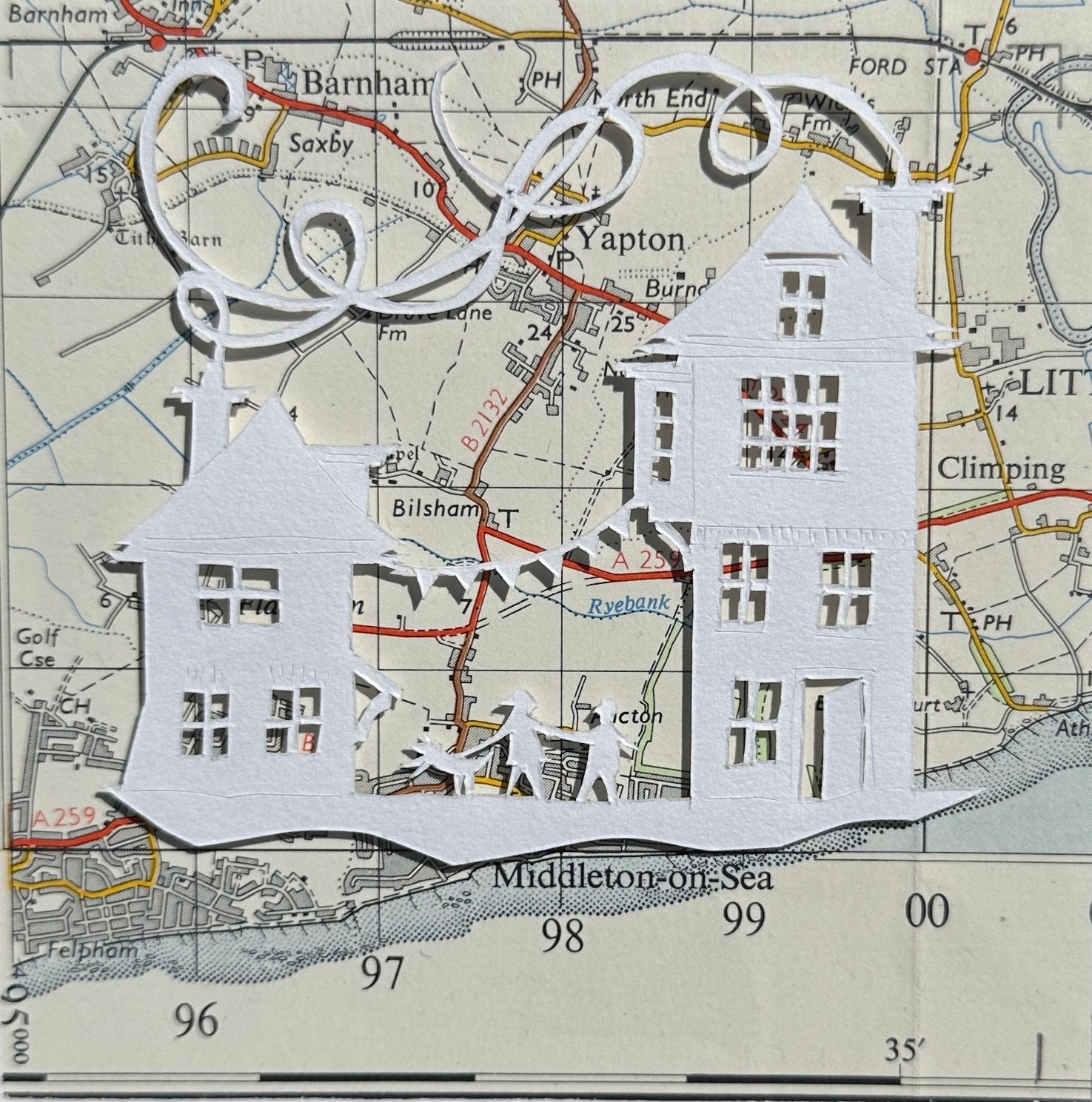 white papercut of two buildings with bunting and tow people and a dog overlaid onto an OS Map extract